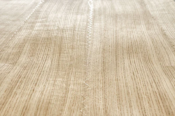 Oak texture as background. Spliced oak veneer with glue thread for furniture manufacturing closeup