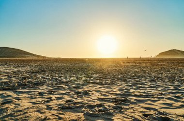 Prasonisi sahilinin kumları yüksek tepelere karşı ve gün batımında yürüyen insanlar Yunanistan 'da yaz geç saatlerinde