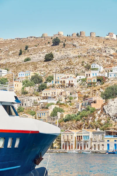 그리스의 색깔의 건물들이 흩어져 역사적 도시와 대비하여 범선들 바다에 — 스톡 사진