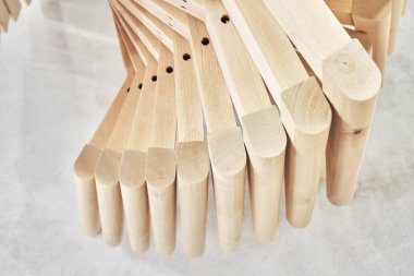 Zarif sandalyeler için sade bacakları olan yeni ahşap tabanlar atölye kapanışında hafif boya püskürtme kabininde toplanıyor.