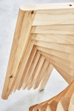 Zarif sandalyeler için sade bacakları olan yeni ahşap tabanlar atölyede hafif boya püskürtme kabinine monte ediliyor.