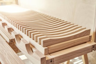 Modern marangozluk atölyesinde kontrplak dolabının yanında, hafif ahşap ahşap ahşap kerestelerden yapılmış şık tabaklar.