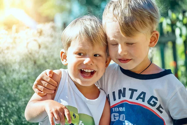 Bambino Abbraccia Felice Fratello Minore Con Piccola Macchina Giocattolo Seduto — Foto Stock