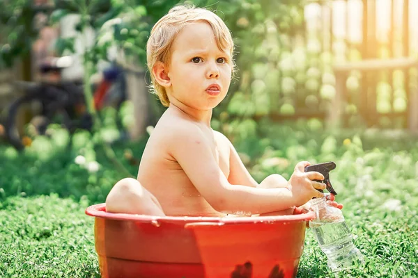 Garotinho Preocupado Bonito Com Garrafa Spray Senta Pequena Bacia Com — Fotografia de Stock