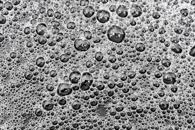 Şiddetli yağmurdan sonra karanlık su yüzeyinde baloncuk desenli yumuşak beyaz köpük yukarıdan dekoratif arka plan görüntüsü olarak