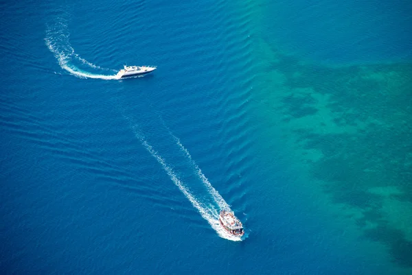 Iates brancos navegando com ondas de espuma em mar azul-turquesa. Vista para drones — Fotografia de Stock