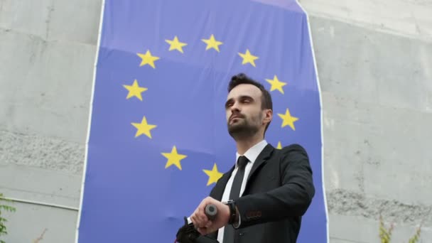 Een Man Een Zakenpak Kijkt Naar Vlag Van Europese Unie — Stockvideo