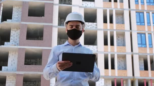 Arquitecto Con Casco Protector Blanco Una Máscara Facial Negra Trabaja — Vídeos de Stock