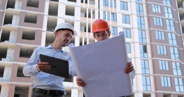 Engineer Tablet Computer Convinces Builder Paper Drawing Construction Correctness Builders — Stock Video