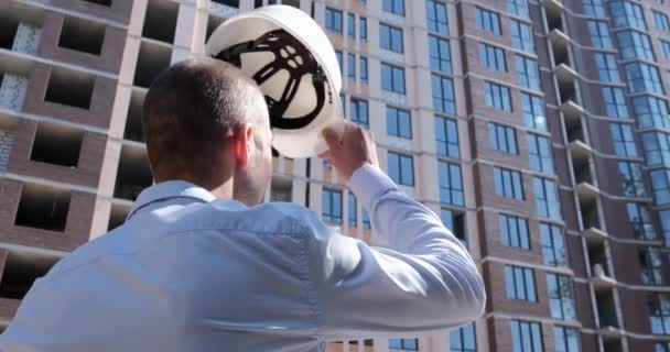 Hombre Con Camisa Pone Casco Blanco Protector Cabeza Mira Edificio — Vídeos de Stock