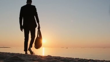 Takım elbiseli bir adam sahile çıkar ve seyahat çantasını güneşe doğru yüzükoyun bırakır. Uzun zamandır beklenen iş adamı tatili.. 