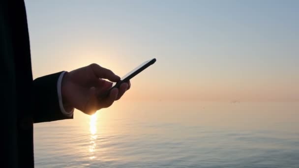 Vicino Uomo Lavora Uno Smartphone Sullo Sfondo Alba Sul Mare — Video Stock