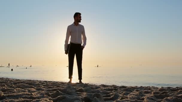 Hombre Con Portátil Está Orilla Del Mar Por Mañana Amanecer — Vídeos de Stock