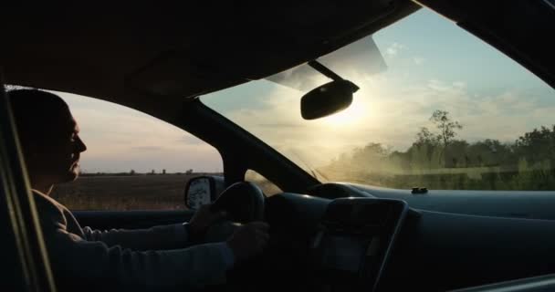 Mężczyzna Jeździ Elektrycznym Samochodem Tle Pracujących Wiatraków Zachodzie Słońca Kamera — Wideo stockowe