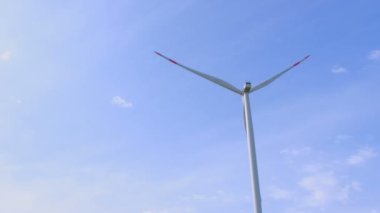 Rüzgâr türbinleri, sirrus bulutlarıyla mavi gökyüzüne doğru döner ve temiz elektrik üretir..