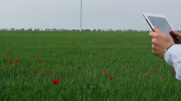 Mężczyzna Pomarańczowym Hełmie Ochronnym Pracuje Tablecie Zielonym Polu Tle Obrotowych — Wideo stockowe