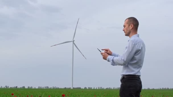 Muž Košili Pracuje Tabletu Dívá Fungující Generátor Větru Stojící Poli — Stock video