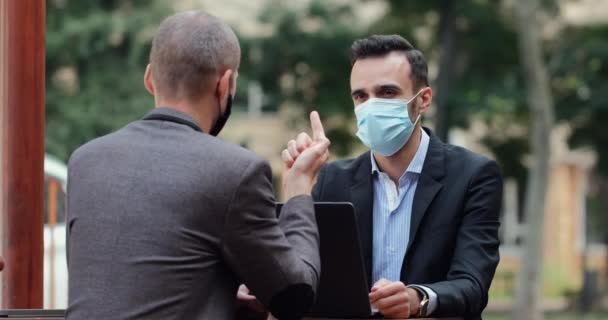 Takım Elbiseli Maskeli Adamlar Ortak Bir Olasılığını Tartışıyorlar Bir Kafenin — Stok video