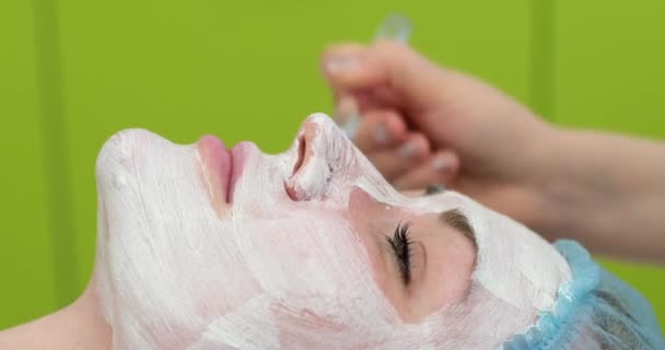 Het Gezicht Van Het Meisje Bedekt Met Een Crème Masker — Stockvideo