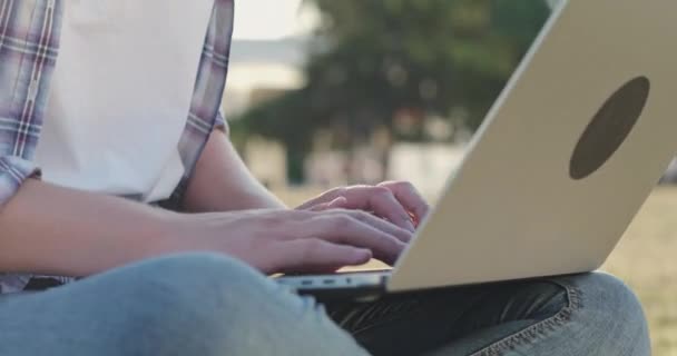 Γυναίκα κάνει την εργασία για το laptop γράφοντας στο σημειωματάριο στο πάρκο — Αρχείο Βίντεο