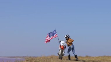 Sportif genç kadın bayrağıyla spor motosikletine biniyor