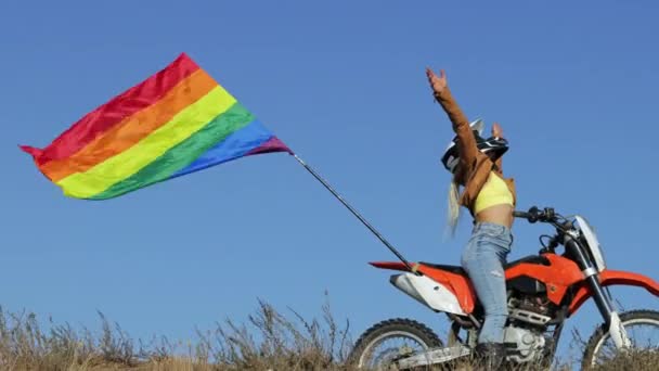 Junge Frau mit langen blonden Haaren auf Sportmotorrad mit Fahne — Stockvideo