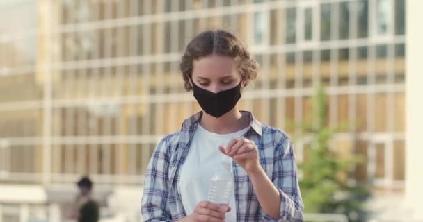 Mujer se quita la máscara para beber agua en la calle de la ciudad primer plano — Vídeos de Stock