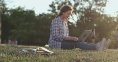 Rüzgar, kitabın sayfalarını dizüstü bilgisayarda yazan öğrencilere karşı çeviriyor