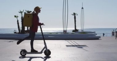 Teslimat çantalı kadın, elektrikli scooter 'la bacaklarını esnetiyor.