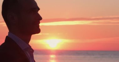 Klasik takım elbiseli adam şişeden su içiyor.