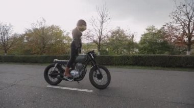 Kasklı ve ceketli sarışın manken yeni motosikletle poz veriyor.