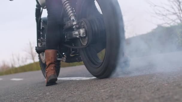 Профессиональный мотоциклист в сапогах горит резина на велосипеде — стоковое видео