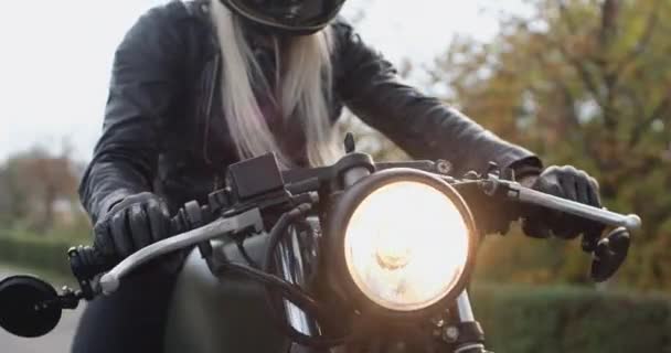Joven mujer rubia motociclista vueltas negro manillar de la motocicleta — Vídeos de Stock