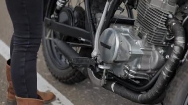 Deri ceketli sarışın bisikletçi motosiklette oturuyor.