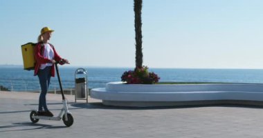 Mavi kazaklı genç bir adam yemek dağıtım servisinde çalışan elektrikli scooterlı bir kızın peşinden koşuyor. Teslimatçı kadın müşterisini terk ediyor..