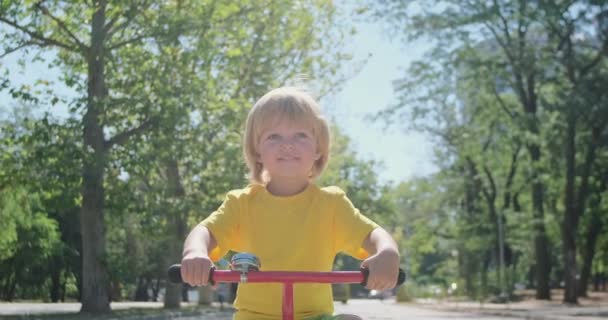 Felice Bambino Biondo Bicicletta Lungo Vicolo Del Parco Sorride Felicemente — Video Stock