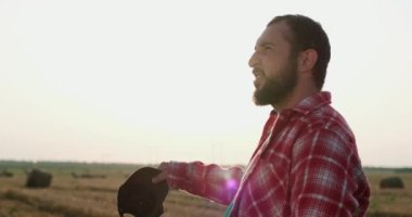 Sakallı çiftçi siyah şapkasını sallar ve başını tarlaya geçirir.