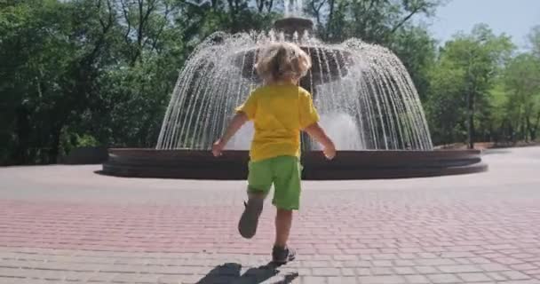 Criança brincalhão deixa triciclo e corre para fonte no parque — Vídeo de Stock