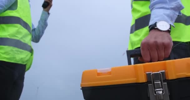 Инженер несет набор инструментов и пожимает руку коллеге — стоковое видео