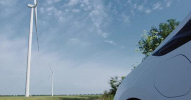 Adam kolunu uzatır ve elektromobil şarj portunu açar