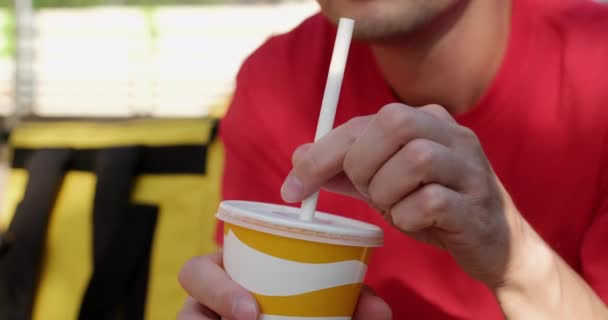 Deliveryman menempatkan jerami ke dalam cangkir untuk menikmati minuman di kafe — Stok Video