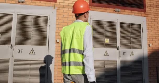 Man in uniform controls electricity distribution substation — Stock Video