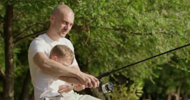 Baba ve küçük oğlu birlikte olta ipini gevşetiyorlar. Adam ve çocuk iskelede oturur ve dikkatlice oltayı açar. Huzurlu bir balıkçılık sabahına başlamaya hazırdırlar.