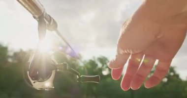 Balıkçı oltayı sıkıca tutarken dikkatlice makarayı çeviriyor. Sudan balık çıkarmak için insan rüzgarı çubuğu. Erkek, balığın direncini bobini döndürürken hisseder.