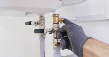 Teknisyen el, ısıtıcıdaki basınç azaltma prizinin altına cam tüp yerleştirdi. Profesyonel tesisatçı test portunu açar ve boşaltma doğrulama işlevini kontrol eder