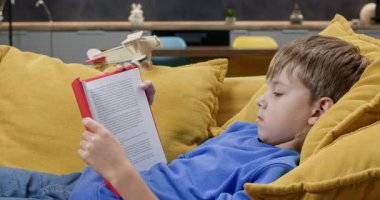 Hayalperest çocuk kitap okuyor ve rahat koltukta tahta oyuncak uçağa biniyor. Küçük okul çocuğu gelecekte uçakla oturma odasında dinlenmeyi planlıyor. Macera Hikayesi