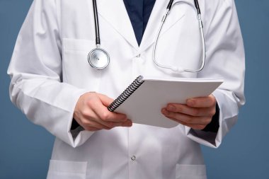 Elinde steteskop ve not defteri olan kadın doktor. Sağlık ve doktor kavramı.