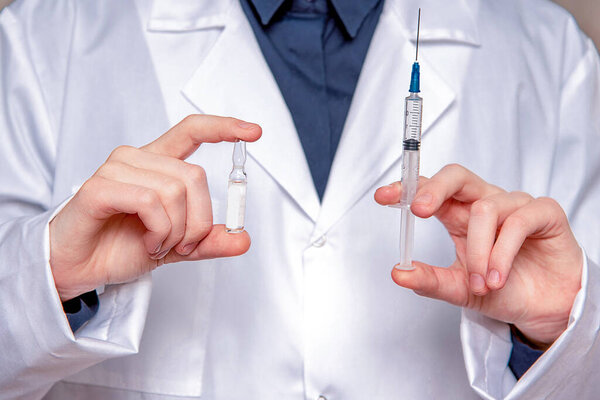 Woman Doctor preparing a vaccine for an injection. The concept of vaccination, filling the drug into the syringe. Doctor background