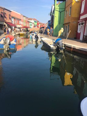 Burano ada kanalı ve Venedik İtalya 'da tekneleri olan renkli evler.