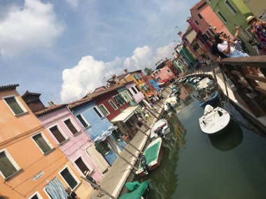 Burano ada kanalı ve Venedik İtalya 'da tekneleri olan renkli evler.